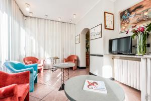 a living room with a table and chairs and a tv at B&B Hotel Souvenir in Cesenatico