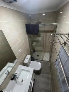 a bathroom with a shower and a sink and a toilet at Brazan Holidays in Corralejo +42 photos
