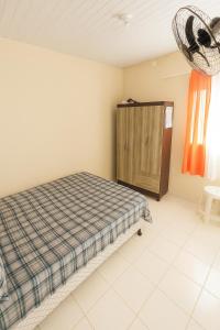 a bedroom with a bed and a wooden cabinet at Rua Projetada 07-lote recreio apartamento 5 loteamento recreio sul barra do Sirinhaém Condomínio residencial barra forte II in Sirinhaém +6 photos