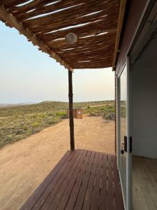 a wooden porch with a view of the desert at Dakotas offgrid camping in Springbok