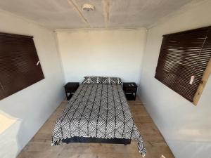 a bed in a room with two windows at Dakotas offgrid camping in Springbok