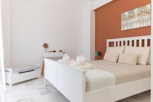 a bedroom with a white bed with towels on it at Dolce Far Niente Apartment in Kalamata