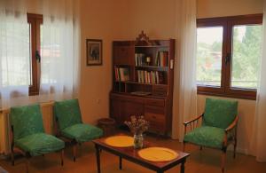 a living room with a table and chairs and a book shelf at Το Περάντι - Επιπλωμένη Οικία Guesthouse in Doliana +14 photos