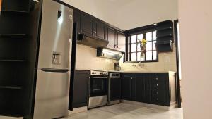 a kitchen with black cabinets and a stainless steel refrigerator at Casa Katerini Bright 3BR with Balcony in Chania Town