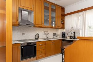 a kitchen with wooden cabinets and a stove top oven at Dolce Far Niente Suite in Kalamata