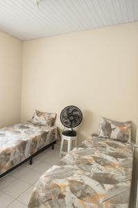a bedroom with two beds and a fan in it at Rua Projetada 07-lote recreio apartamento 5 loteamento recreio sul barra do Sirinhaém Condomínio residencial barra forte II in Sirinhaém
