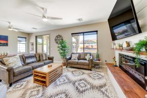 a living room with a couch and a tv and a fireplace at San Tan Valley Vacation Rental with Community Perks! in San Tan Valley