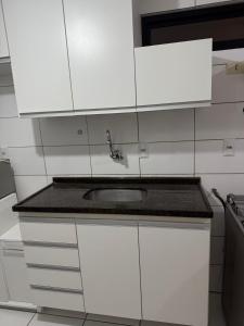een keuken met witte kasten en een spoelbak bij Apartamento em Maceió in Maceió