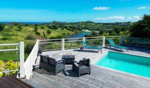 a deck with a pool and a view of the ocean at Bungalow la paillote in Le François