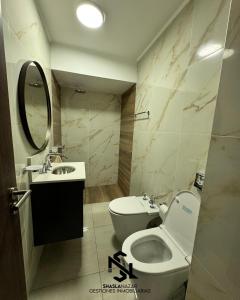 a bathroom with a toilet and a sink and a mirror at departamento en edificio torre libertador in Río Tercero