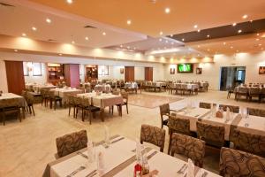 a banquet hall with tables and chairs in a restaurant at Kolhida Complex in Elkhovo
