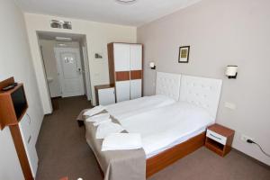 a small bedroom with a bed and a tv at Kolhida Complex in Elkhovo +14 photos
