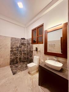 um banheiro com vaso sanitário, pia e chuveiro em Ceylan Breeze Beach Resort em Tangalle