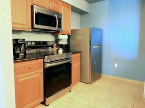 a kitchen with a stainless steel refrigerator and a microwave at Resort Lake Buena Vista - 2 Quartos in Vineland