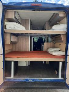 an open door of a van with beds in it at Caravana Poço Bispo in Lisbon