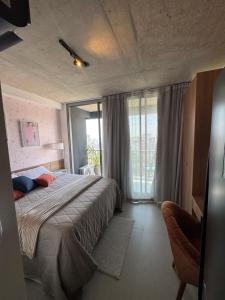 a bedroom with a bed and a large window at Uma delícia de Ap para SP! in Sao Paulo