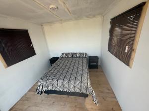 a bedroom with a bed in a room with two windows at Dakotas offgrid camping in Springbok +9 photos