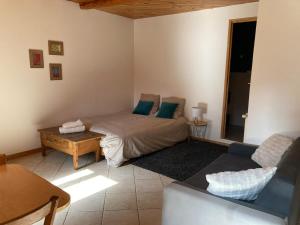 a living room with a bed and a couch at Studio Serre Chevalier Briancon in Briançon