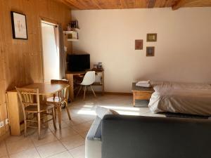 a bedroom with a bed and a table and a desk at Studio Serre Chevalier Briancon in Briançon