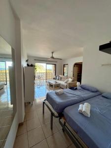 a bedroom with two beds and a living room at Apartamento tranquilo con vistas in Los Realejos