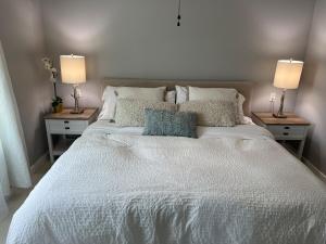 un grande letto bianco con due lampade su due tavoli di Modern Miami Gem, Fresh Studio by Coral Gables #4 a Miami
