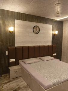 ein Schlafzimmer mit einem Bett und einer Uhr an der Wand in der Unterkunft The family courtyard in Amritsar