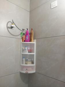 ein Badezimmer mit einem Regal mit Shampoo und anderen Reinigungsprodukten in der Unterkunft The family courtyard in Amritsar