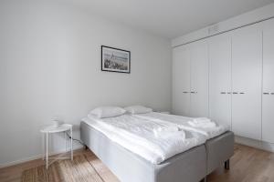a white bedroom with a bed and white cabinets at "Ketlari"- Homelike 1BR Apartment with Sauna in Historic Area, Hosted by 2ndhomes in Tampere