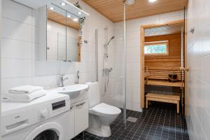 a white bathroom with a toilet and a sink at "Ketlari"- Homelike 1BR Apartment with Sauna in Historic Area, Hosted by 2ndhomes in Tampere