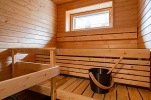 a wooden sauna with a bucket in it at "Ketlari"- Homelike 1BR Apartment with Sauna in Historic Area, Hosted by 2ndhomes in Tampere