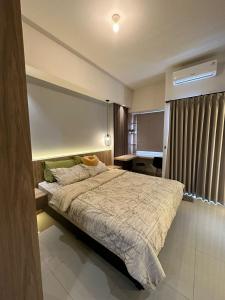 a bedroom with a large bed in a room at The Avenue Parkland Serpong by Ngeroomin in Babakan +6 photos