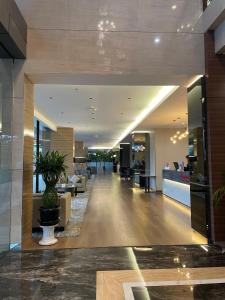 a lobby of a building with a potted plant at The Avenue Parkland Serpong by Ngeroomin in Babakan