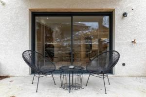 due sedie e un tavolo davanti a una finestra di La Grange premium avec terrasse et parking a Thoiry