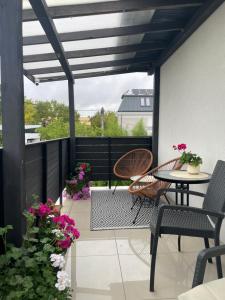 a patio with a table and chairs and flowers at Madi Apartamenty in Sandomierz