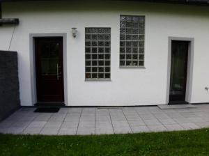 ein weißes Haus mit zwei Fenstern und einer Tür in der Unterkunft Ferienhaus Suedhang in Winterberg