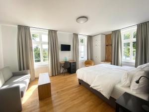 a bedroom with a large bed and a couch at Backbord Geesthacht in Geesthacht