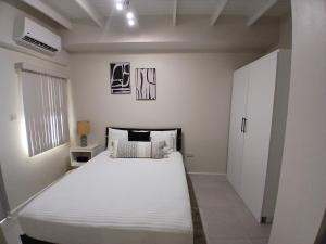 Schlafzimmer mit einem großen weißen Bett in der Unterkunft Atrium Apartments - Nutmeg Nook in Grand Anse