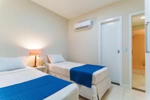 a hotel room with two beds and a tv at Apartamento Beverly Hills - Porto das Dunas in Mangabeira +29 photos