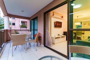 a room with a balcony with a table and chairs at Apartamento Beverly Hills - Porto das Dunas in Mangabeira