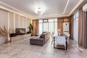a living room with a table and a couch and a fireplace at City Villa in Koktobe
