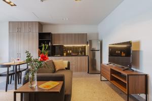 a living room with a couch and a table and a kitchen at Stylish Studio w Gym & Pool Access VIATO HOMES in Mexico City