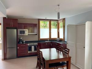 a kitchen with a wooden table and a kitchen with a table and chairs at Apartamento Casa Maru in Santillán