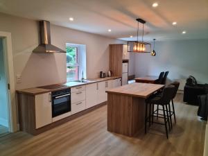 a kitchen with a table and a stove top oven at Modern 2 bedroom Apartment with River views in Behy Bridge