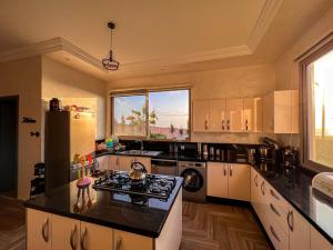 a large kitchen with a stove and a refrigerator at Room 2 Villa sunset Moulay Bouzerktoun in Essaouira