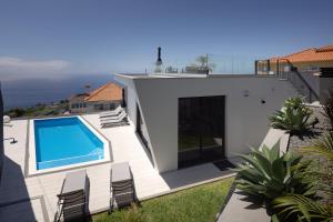 eine Villa mit Swimmingpool und ein Haus in der Unterkunft A&M House III in Arco da Calheta