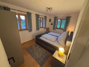 a living room with a bed and a table with a lamp at Entspannung auf dem Land in Dietramszell