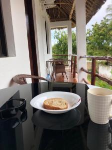 a plate of bread on a table with a cup of coffee at SouthCoast Outdoors in Ukunda