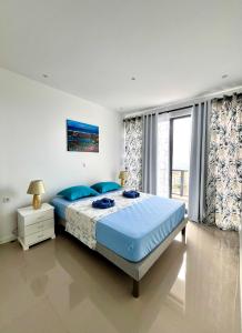a bedroom with a large bed with blue pillows at Casa BB&Djassi - Apartment T2 in Ponta do Sol