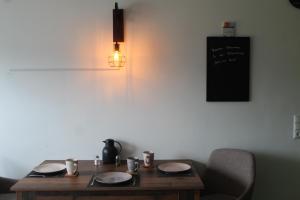 a wooden table with plates and a light on a wall at Blick zur Heide in Volkesfeld +26 photos