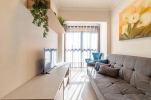 a living room with a couch and a television at Apto funcional no Centro de Blumenau UG6156 in Blumenau